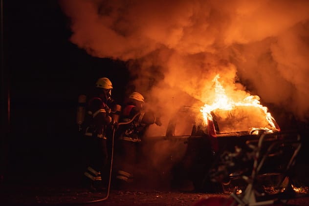 Firefighters extinguishing ICE car blaze